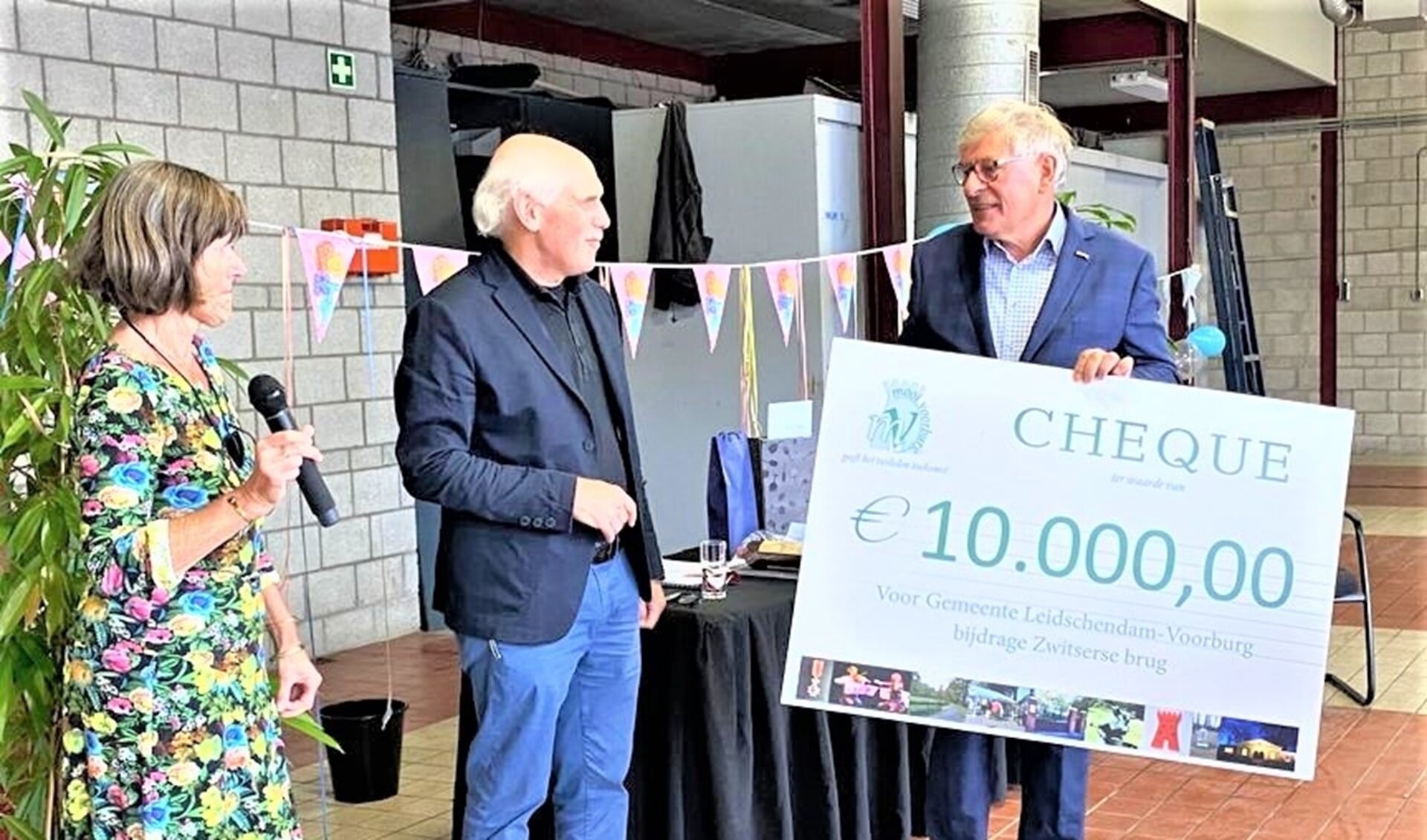 Frouwke de Boer en Joost Heuvelink van Mooi Voorburg overhandigen Rob Gussekloo de cheque (foto: gemeente Leidschendam-Voorburg).