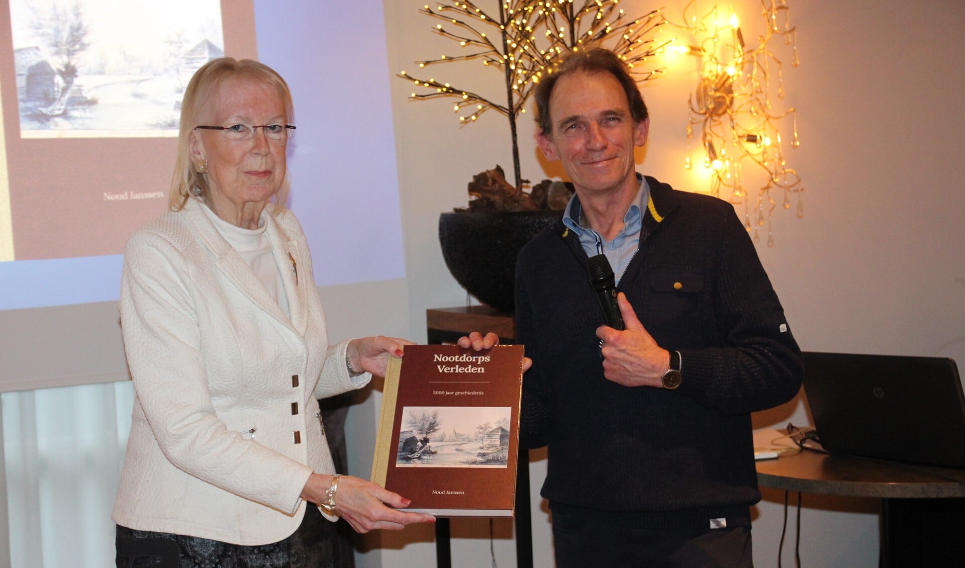Burgemeester Francisca Ravestein ontvangt het eerste exemplaar uit handen van auteur Noud Janssen.