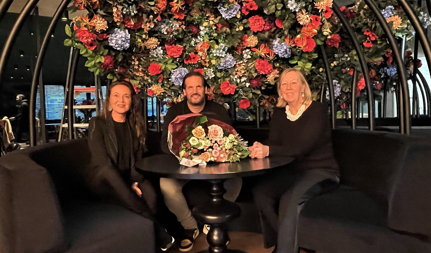Rein Rambaldo ontvangt in zijn nieuwe restaurant Miss Jones bloemen van wethouder Astrid van Eekelen (rechts) en de voorzitter van MKB Leidschendam-Voorburg Benedikte Zijlstra (links) (foto: gemeente LV).
