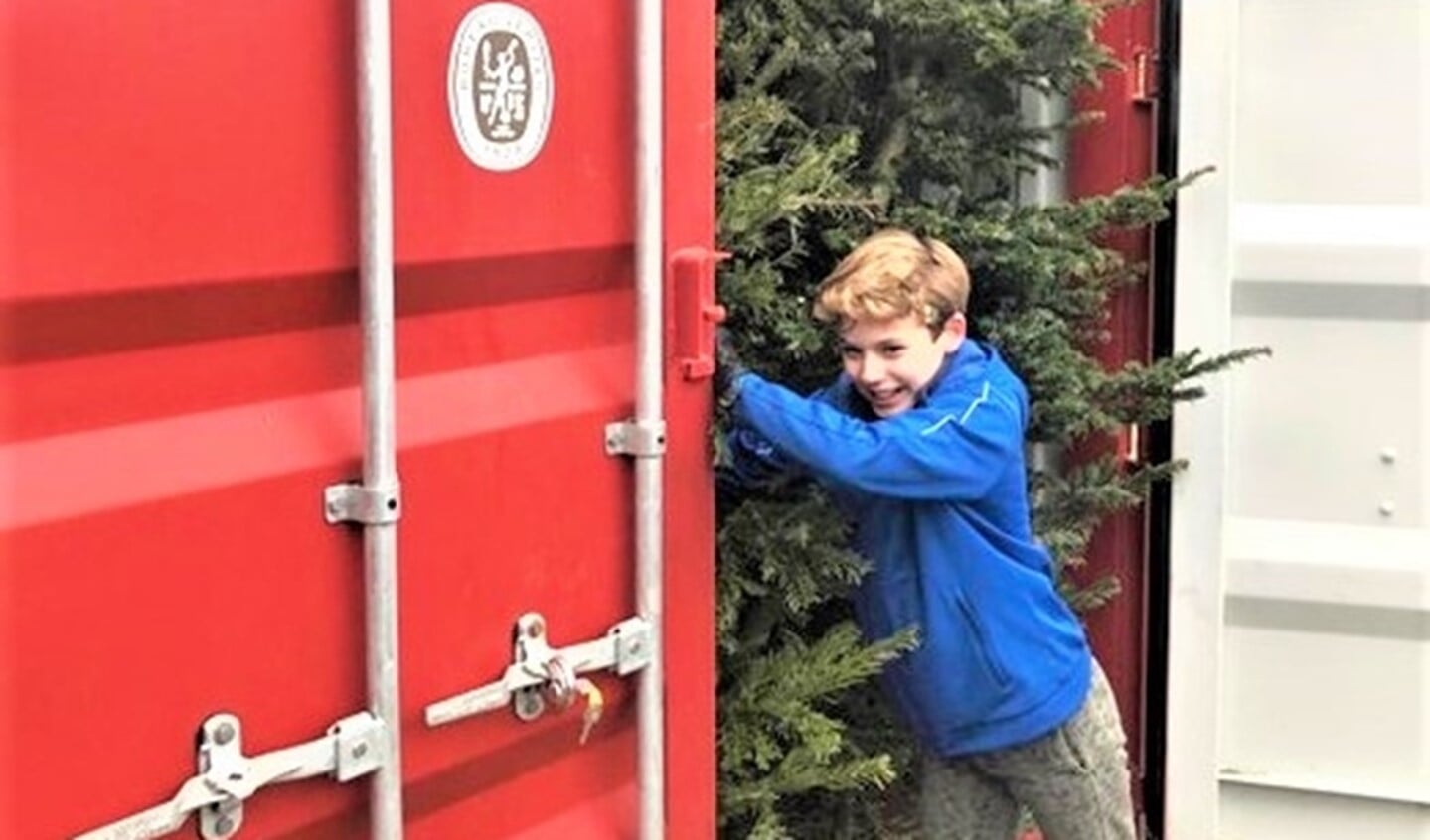 Walter bij de container waarin hij de door hem voor Kika opgehaalde kerstbomen vorige jaar opsloeg (eigen foto).