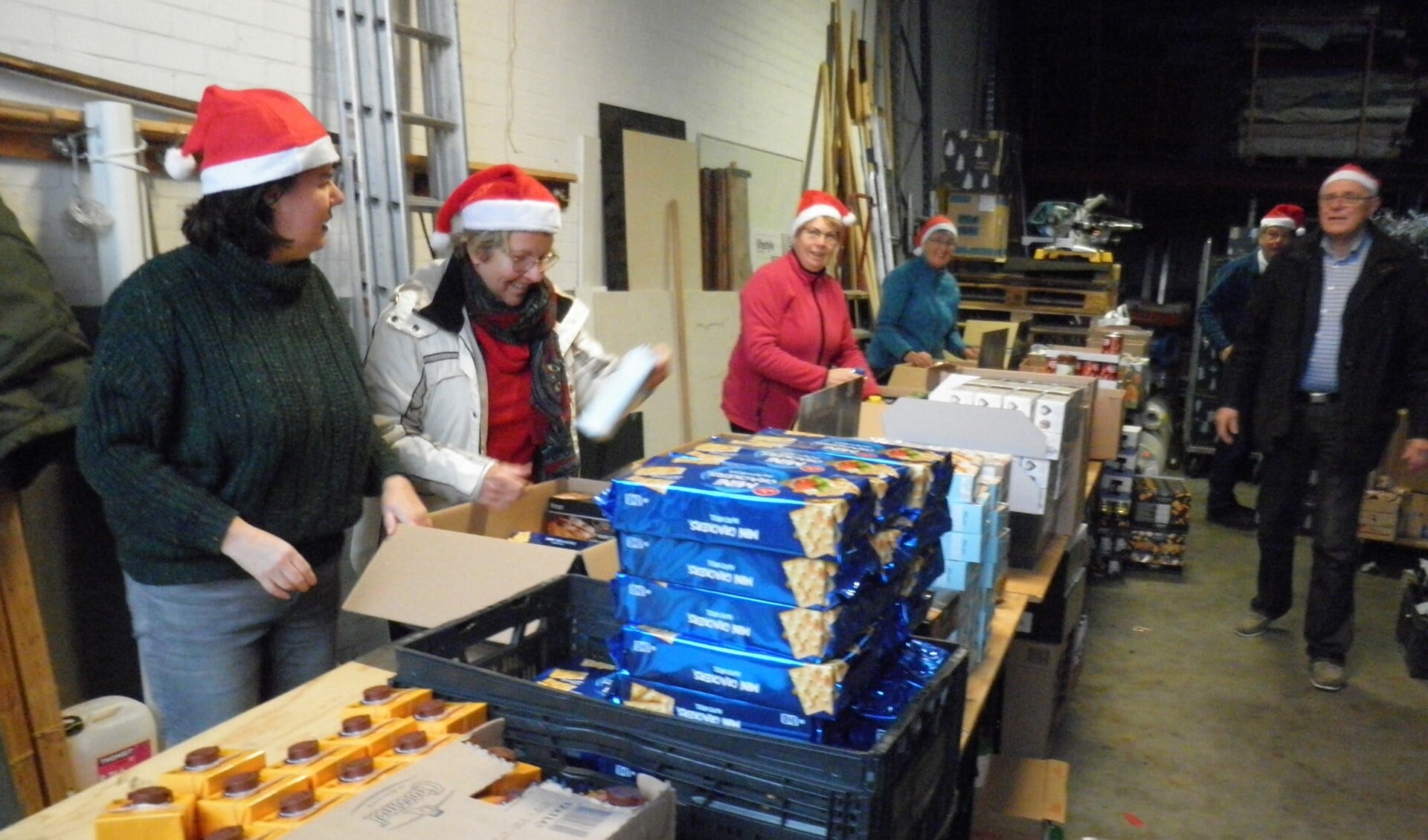 Bij Van der Goes Interieur aan de Plesmanstraat zijn vrijwilligers van de Vincentiusvereniging Zoetermeer bezig met het samenstellen van de kerstpakketten. Foto Kees van Rongen