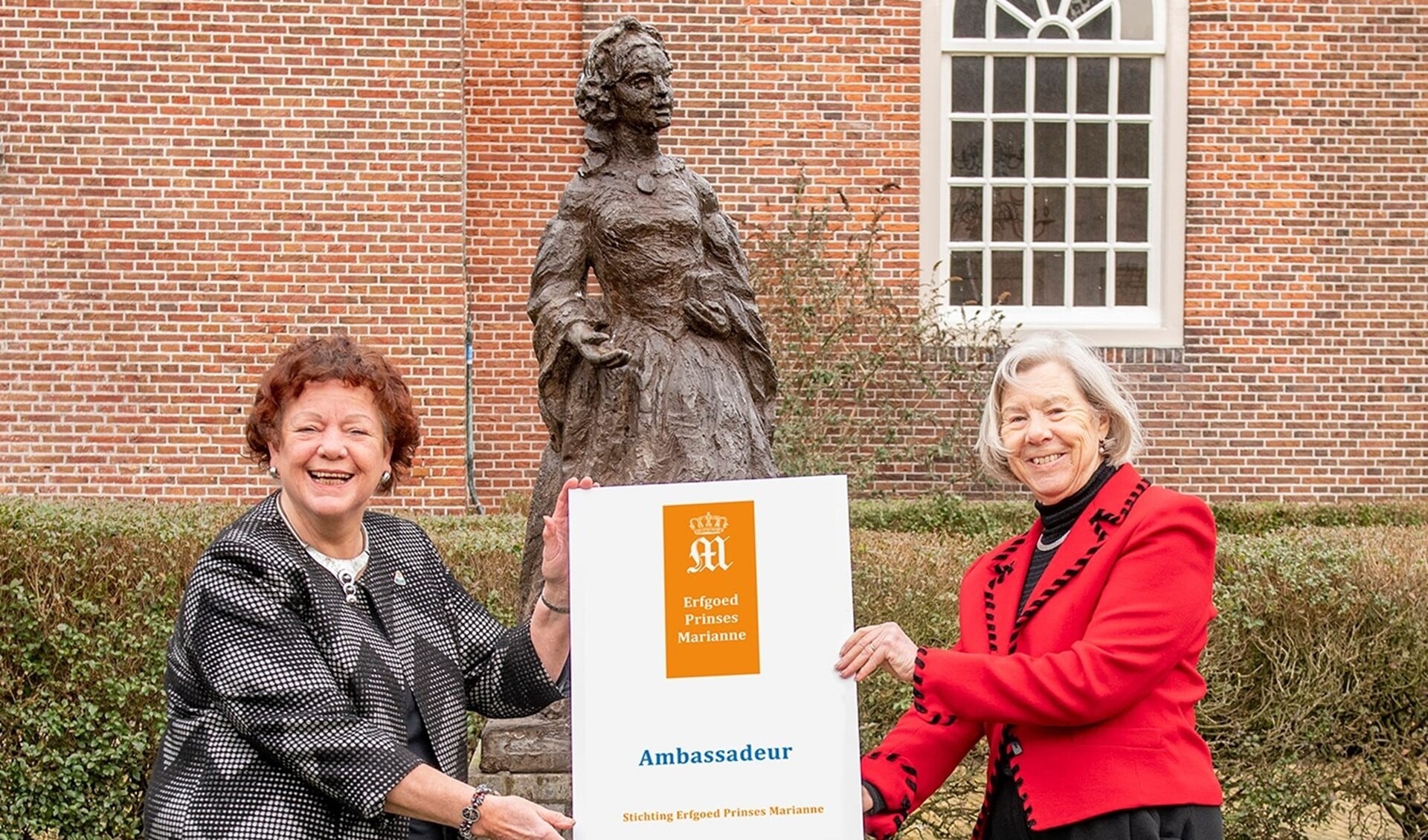 Tilly Zwartepoorte overhandigt Marianne Knijnenburg (links) het titelbord Ambassadeur (foto Ronald Meekel).