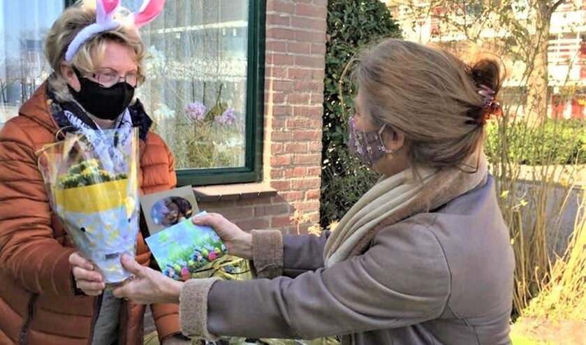 Namens het Voorburgs Operakoor wordt een paaspresentje overhandigd aan een koorlid (foto: pr).