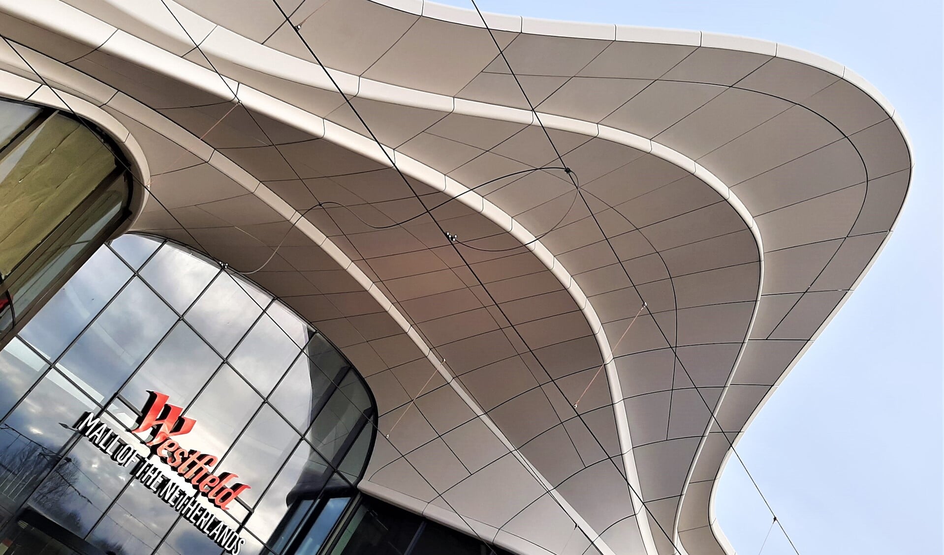 De vloeiende witte lijnen die de gevel kenmerken zijn als een zijden sjaal die om het gebouw is gewikkeld en ogen gracieus en verbindend (foto: Hans van Veen).