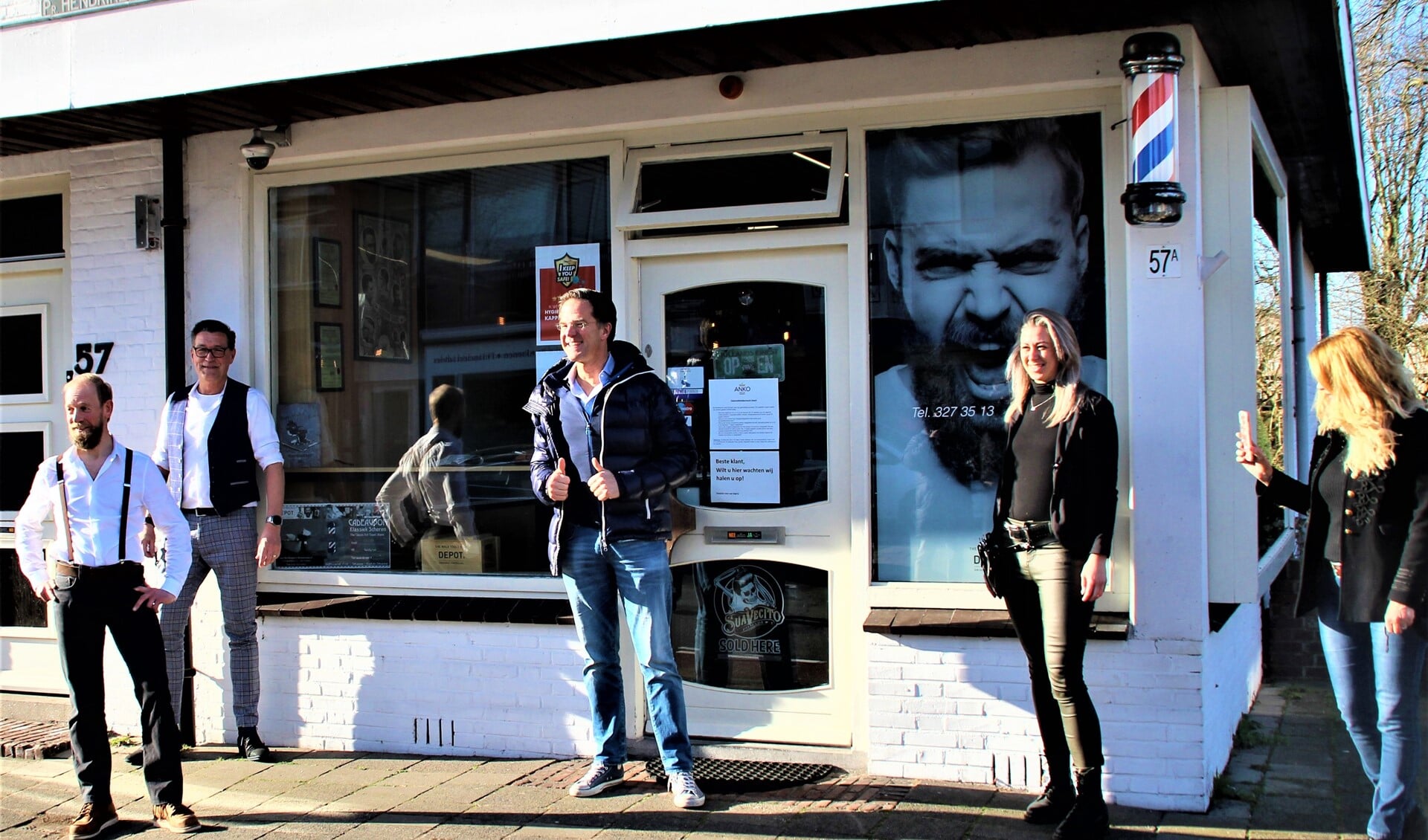 Mark Rutte voor de deur van de kapsalon van Marco Rimmelzwaan (uiterst links) in Leidschendam (foto: VR Press).