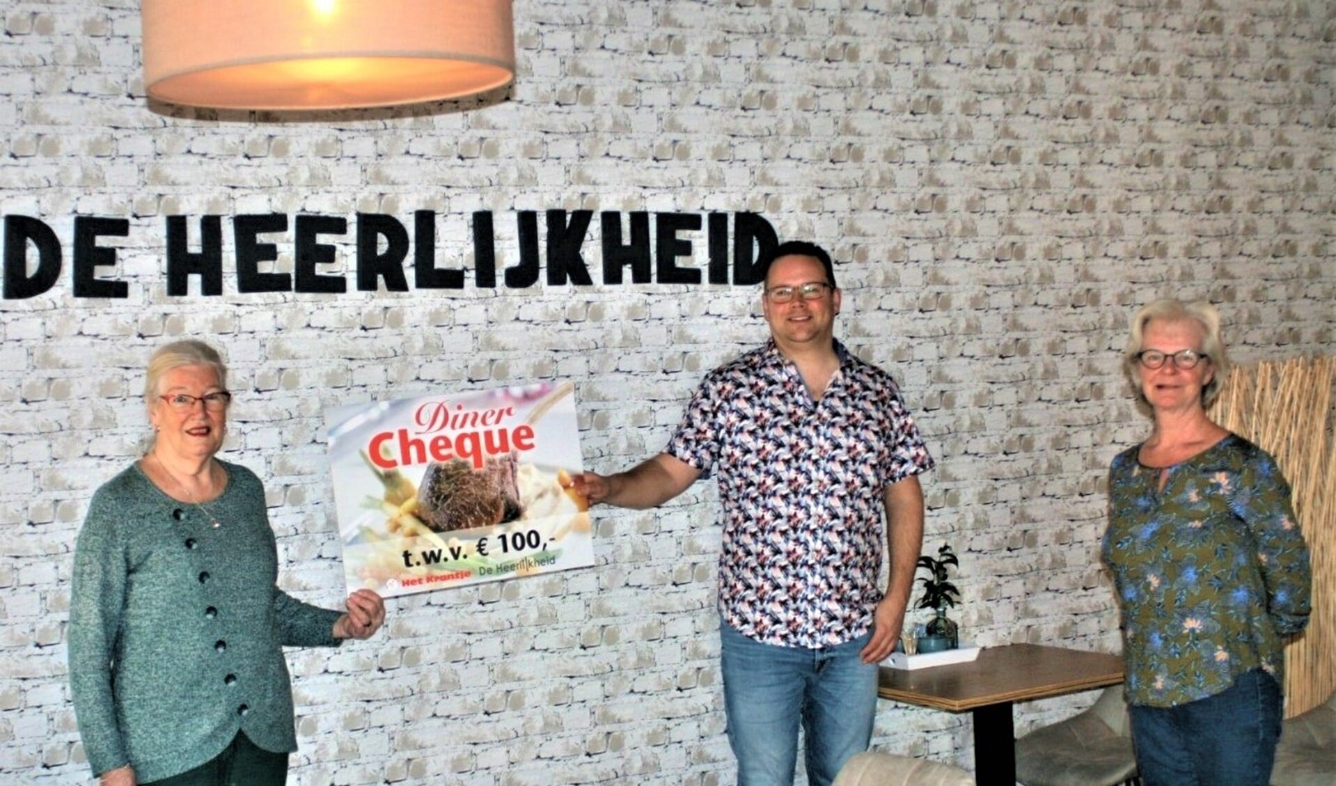Oscar van Schijndel en Ingrid Blom van De Heerlijkheid overhandigen de cheque op gepaste afstand aan Riet Jongstra-Blommaert. 