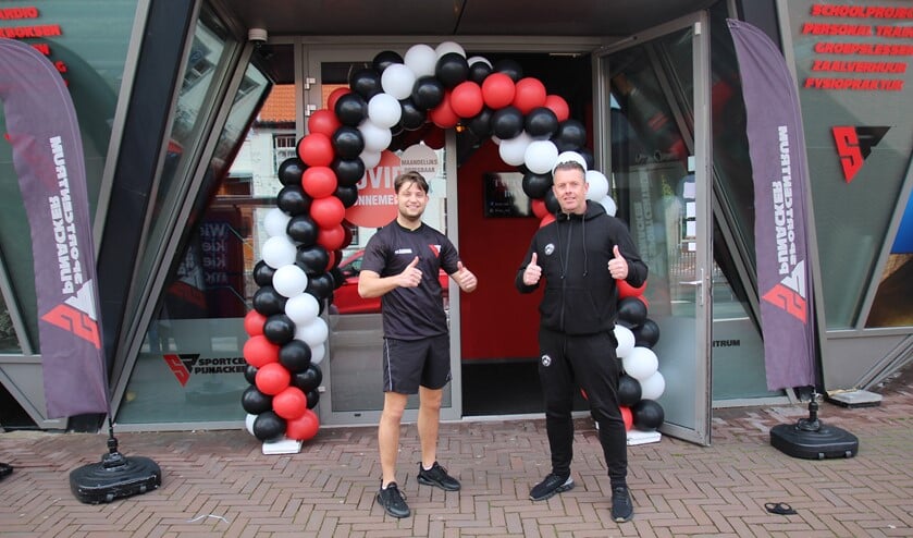 <p>Dave Nijhuis en zijn collega Gerald Lagrand onder de ballonnenboog bij de entree van Sportcentrum Pijnacker.</p>