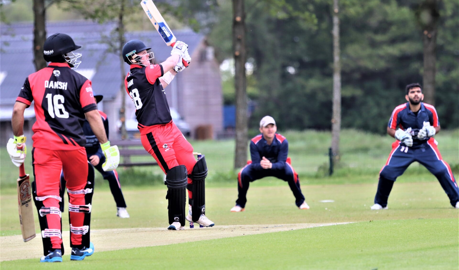 De jonge Zuid-Afrikaan Garnett Tarr slaat een bal van Logan van Beek het veld uit. Tom de Grooth en Mohit Hingorani kijken toe (foto: Catch of the Day BV).