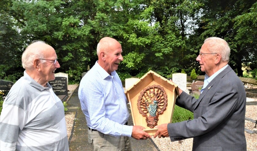 <p>Johan van Reisen overhandigt een kopie van het beeldje 'Maria van Wilsveen' aan de beheerder van de begraafplaats, Wijnand Wiegeraadt. Links Jan van Santen die er een kapelletje voor maakte (foto: pr).</p>