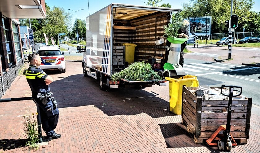 <p>De restanten van de wietkwekerij worden onder toezicht van de politie afgevoerd op de Oude Trambaan in Leidschendam (foto; Sebastiaan Barel).</p>