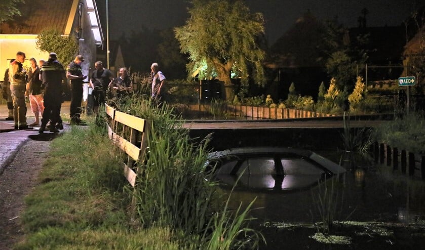De auto half in het water in de beruchte bocht in Wilsveen (foto: Sebastiaan Barel).