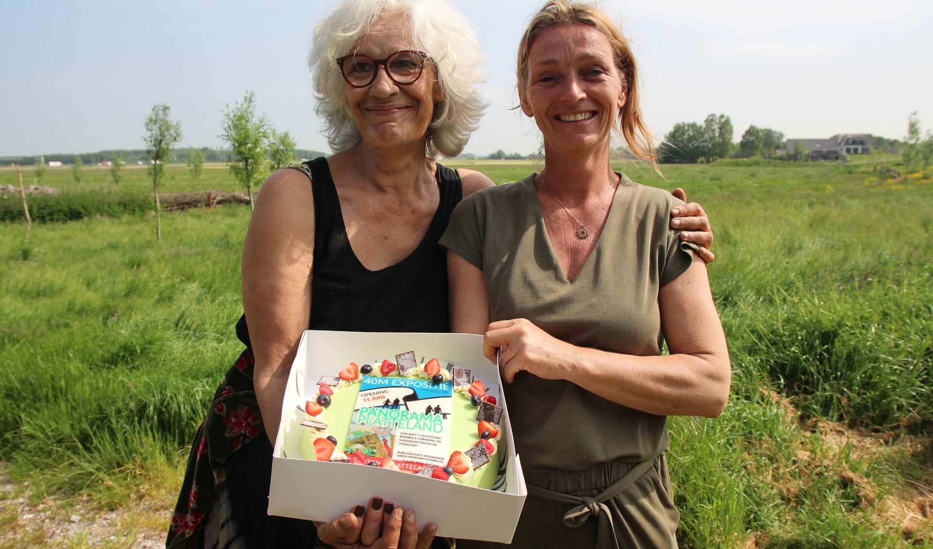 Cis en Vicky sneden met de kunstenaars een taart om de afronding van het project te vieren.