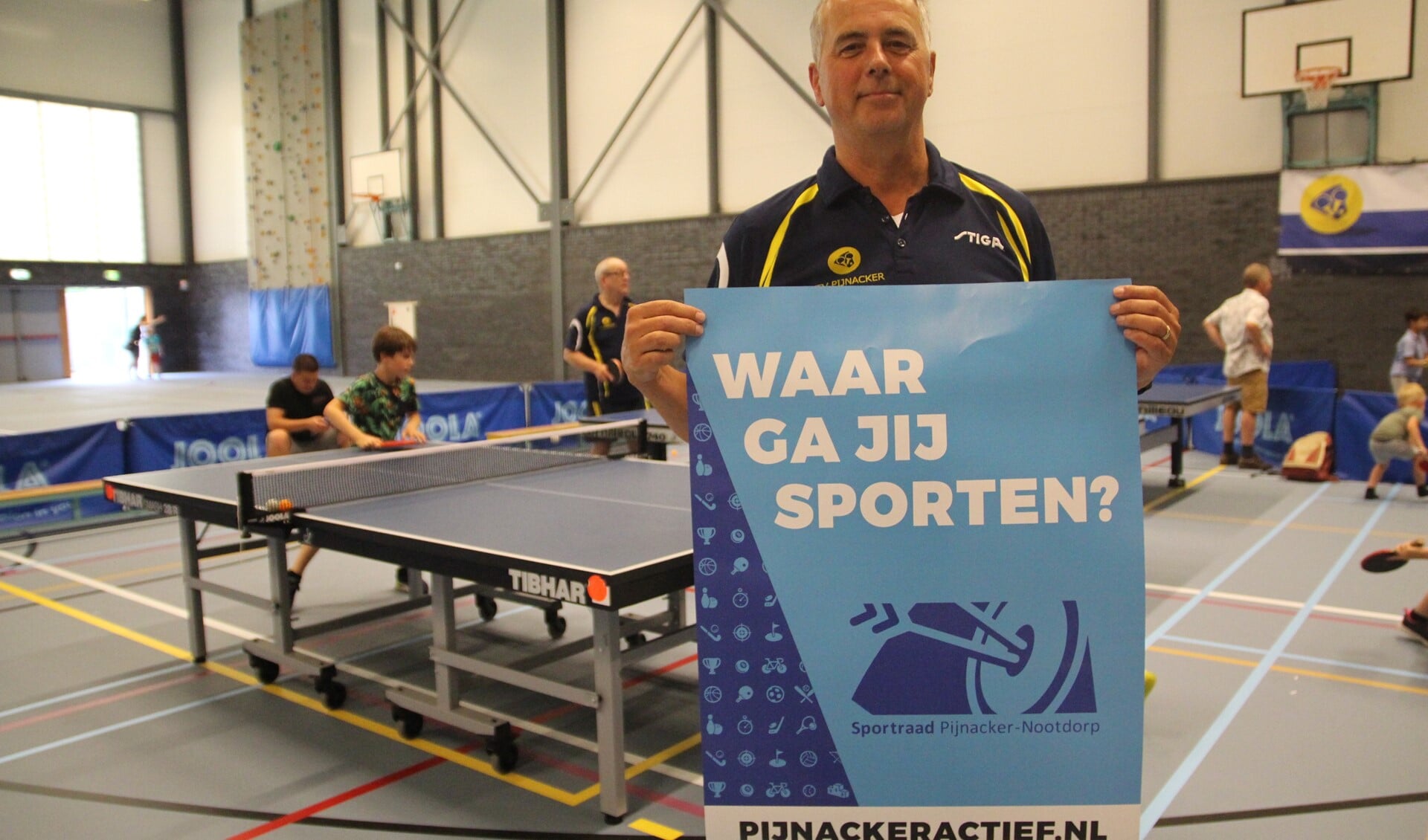 Roel van der Beek tijdens de Sportmarkt in De Viergang met een poster die nu ook in de hele gemeente langs de weg te zien is.