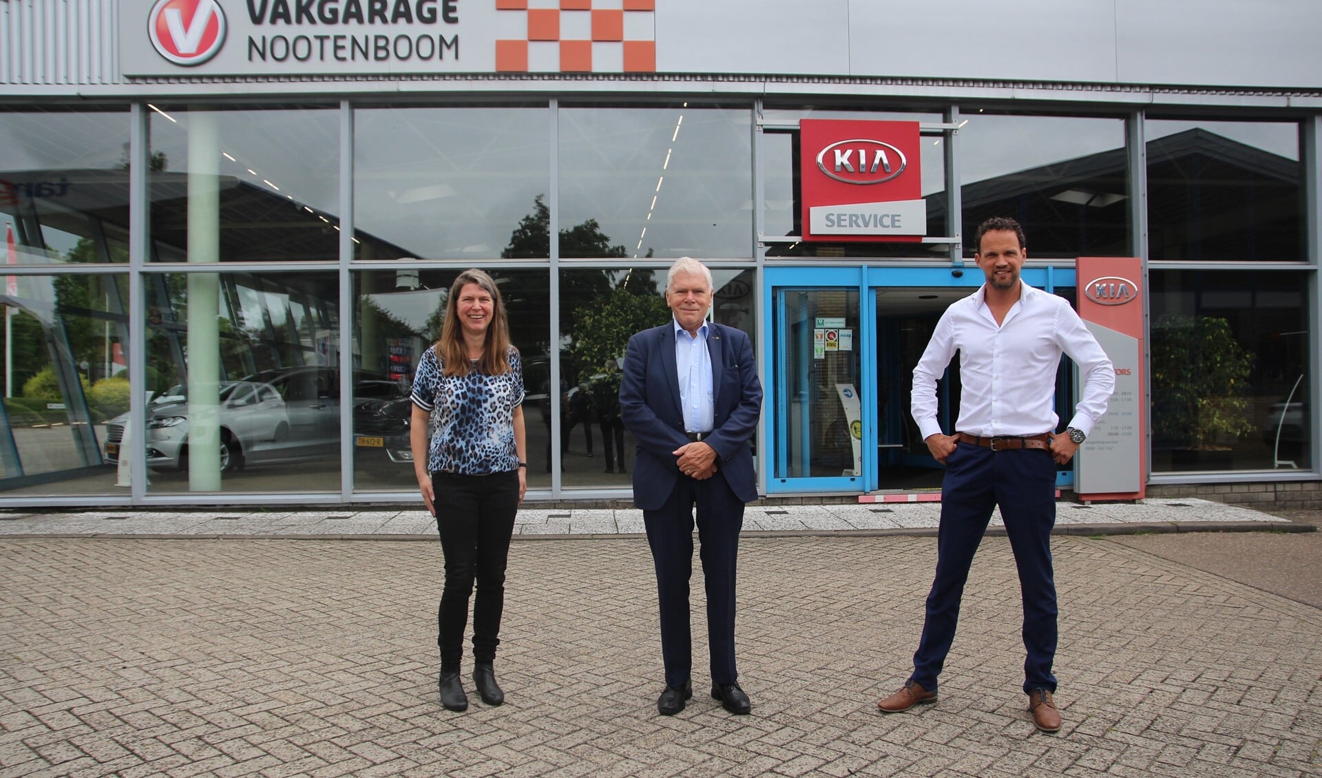 Claudia, Henk en Menno voor de showroom van Autobedrijf Nootenboom aan de Oudeweg.