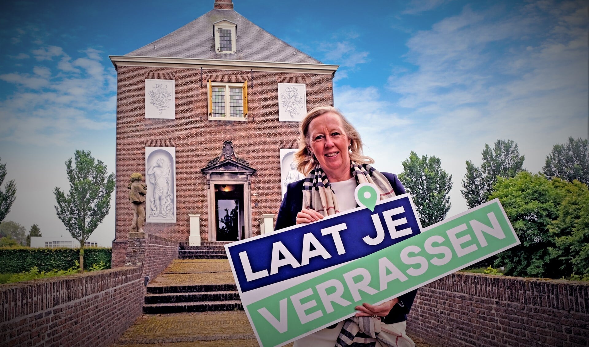 Astrid van Eekelen met bord met boodschap ‘laat je verrassen’ (foto: pr gemeente LV).