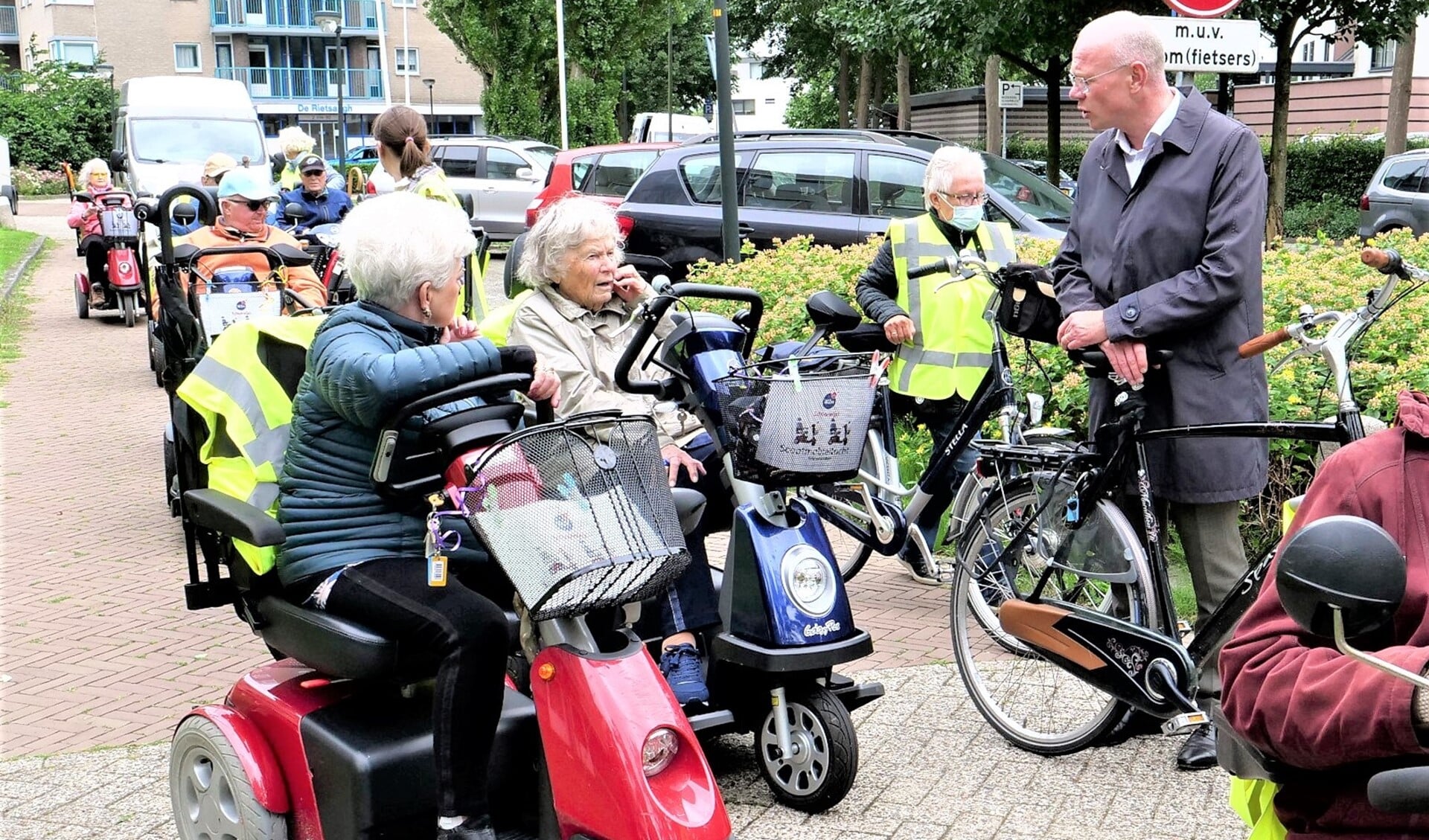 Start van de scootmobieltocht met deelnemers in gesprek met burgemeester Klaas Tigelaar (foto: Ot Douwes).