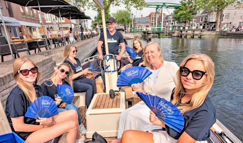 <p>Vanaf een boot deelde de wethouder waaiers uit (foto: gemeente LV).</p>