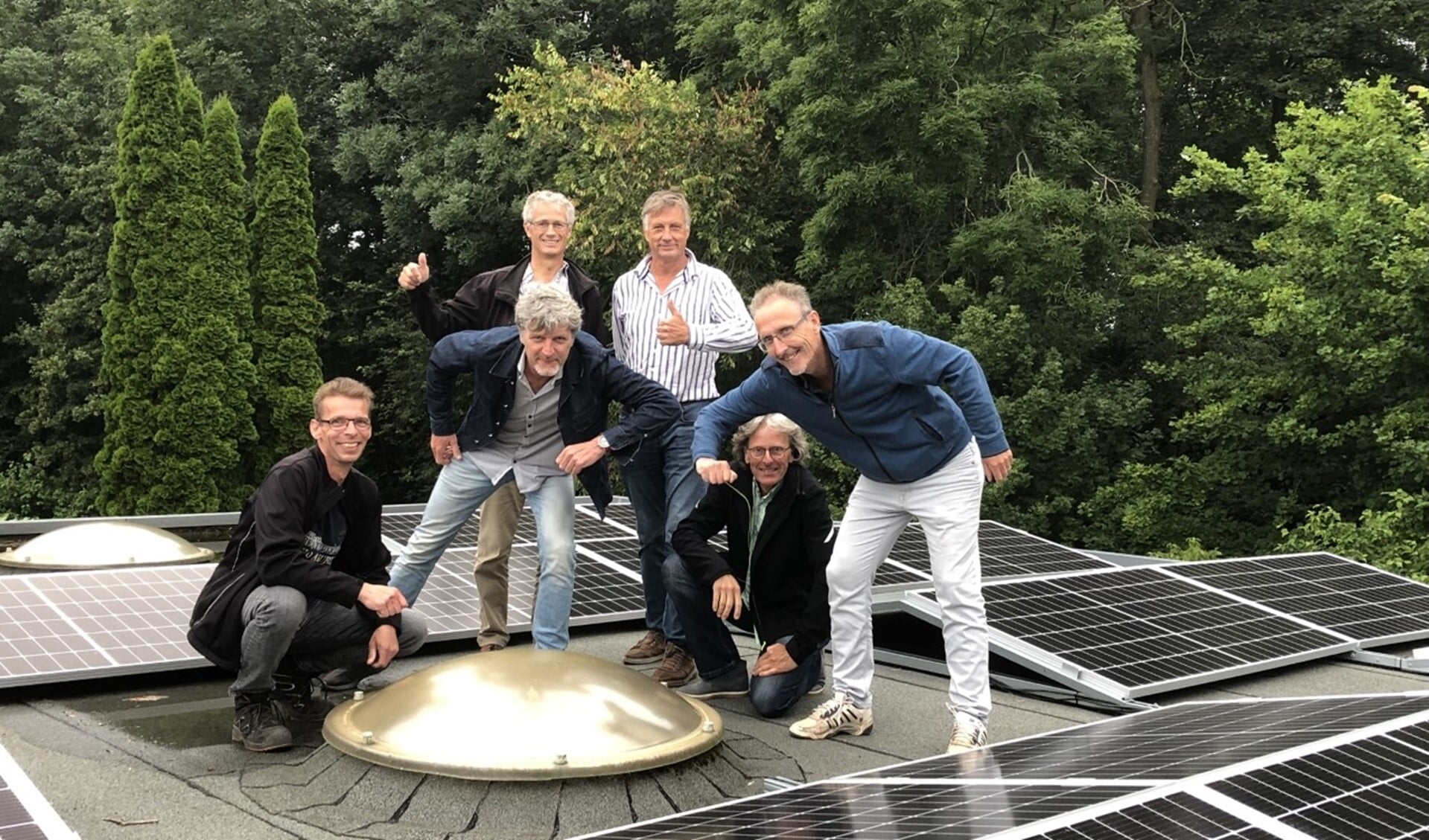 Het projectteam bewondert de zonnepanelen op het dak.