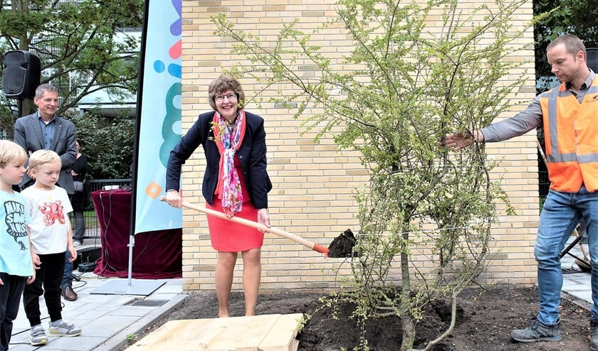 <p>Wethouder Juliette Bouw plant een boom als aandenken aan de opening van Kindcentrum MMiXX aan De Tol (foto: Michel Groen).</p>