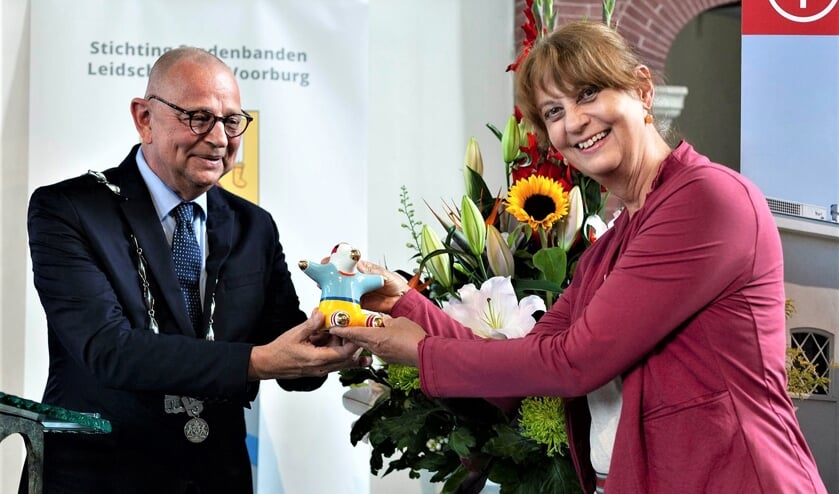 <p>Noor Kamerbeek ontvangt de gemeentelijke onderscheiding de UBU uit handen van burgemeester Jules Bijl (foto: Hilbert Krane).</p>