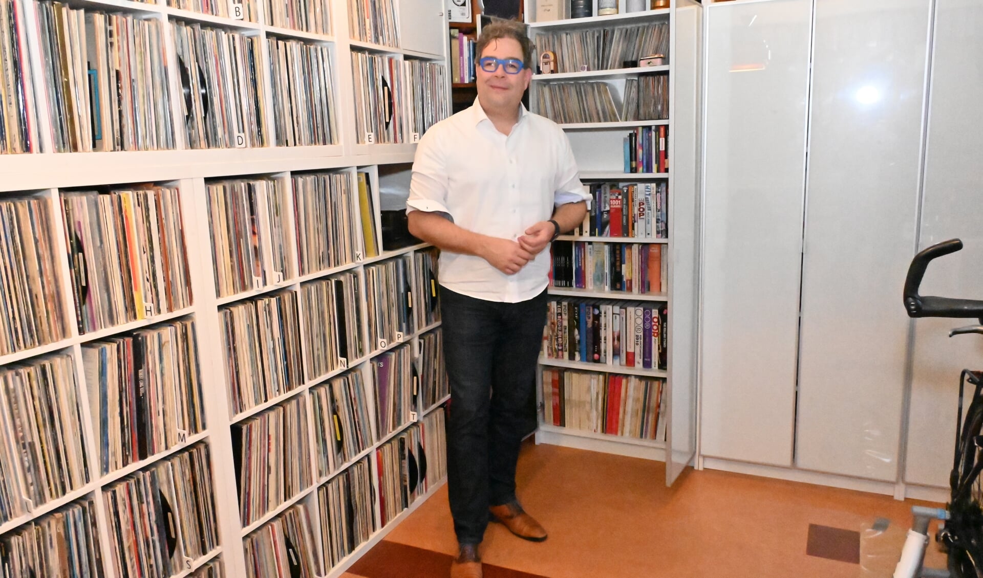 Jan Iedema bij zijn gecombineerde boeken en vinylkast. Foto: Gerard van Warmerdam