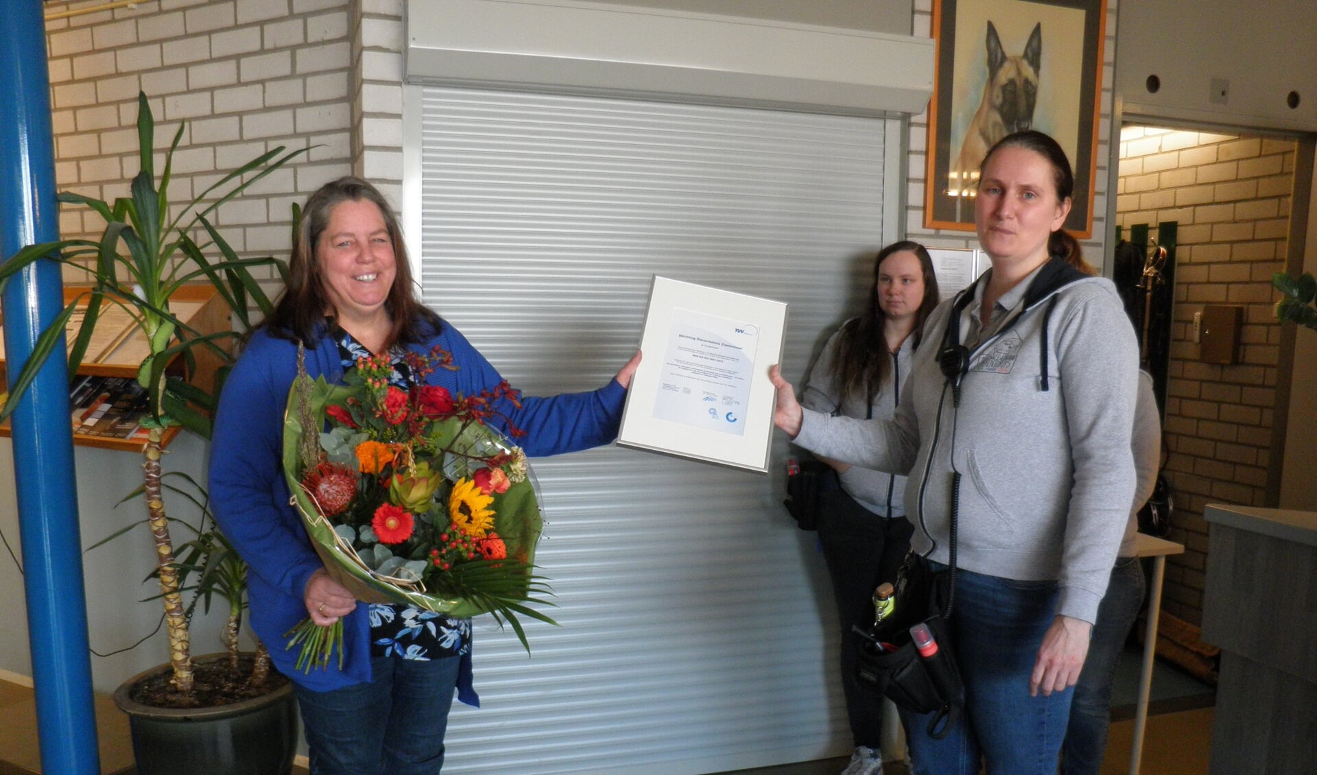 Francisca van den Broeke van TÜV (l) overhandigt het kwaliteitscertificaat ISO 9001 aan beheerder van het Dierentehuis Zoetermeer Fenna in ’t Veld. Foto Kees van Rongen