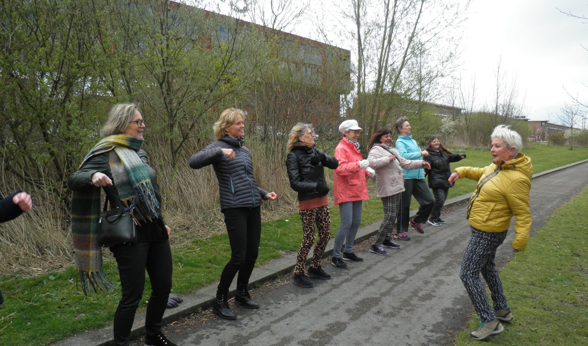 Beweegcoach Georgette Parlevliet begint met een warming up, waaraan ook wethouder Ingeborg ter Laak (tweede van links) enthousiast mee doet. Foto Kees van Rongen