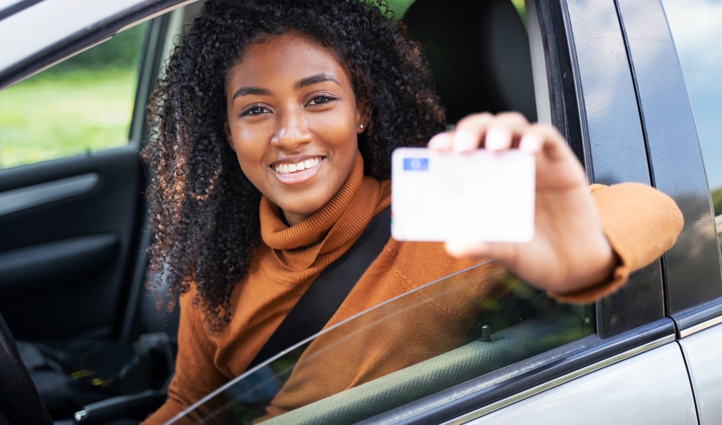 Vrouw toont haar rijbewijs, dat je nu ook online kunt laten verlengen in de gemeente Leidschendam-Voorburg.