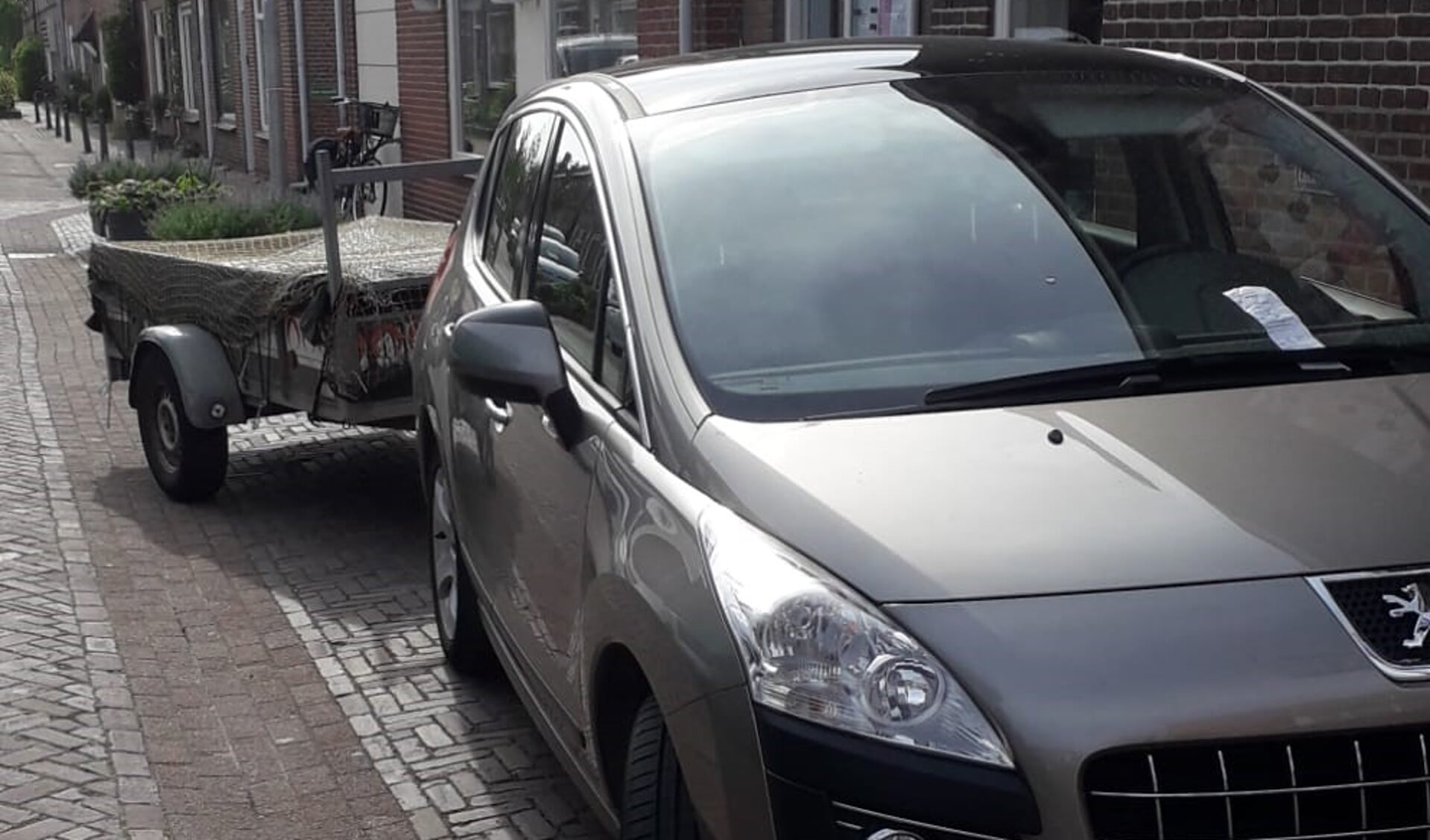 De auto met aanhanger van de winkel Terre des Hommes waarmee iedere maandag niet meer verkoopbare spullen naar Avalex worden gebracht. Op 2 mei zat er ineens een bon van 100 euro onder de ruitenwissers.