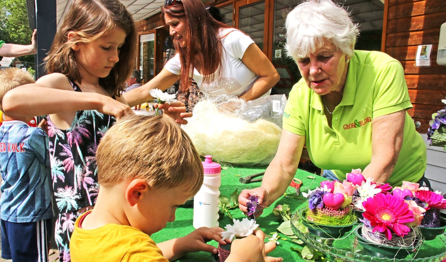 Kinderen maken bloemstukjes in de Stadstuin Rusthout (foto: pr Groei & Bloei).