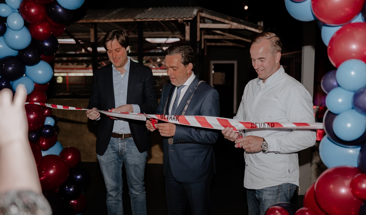 Eigenaar Wim van der Kooij (links) en bedrijfsleider Fred Buisman knippen samen met de burgemeester het lint door (foto: Game-city)