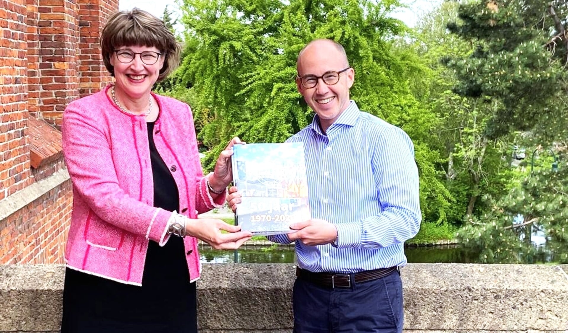 Rector Philip de Vries overhandigde een exemplaar van het jubileummagazine van het Veurs Lyceum aan wethouder Juliëtte Bouw (foto: pr).