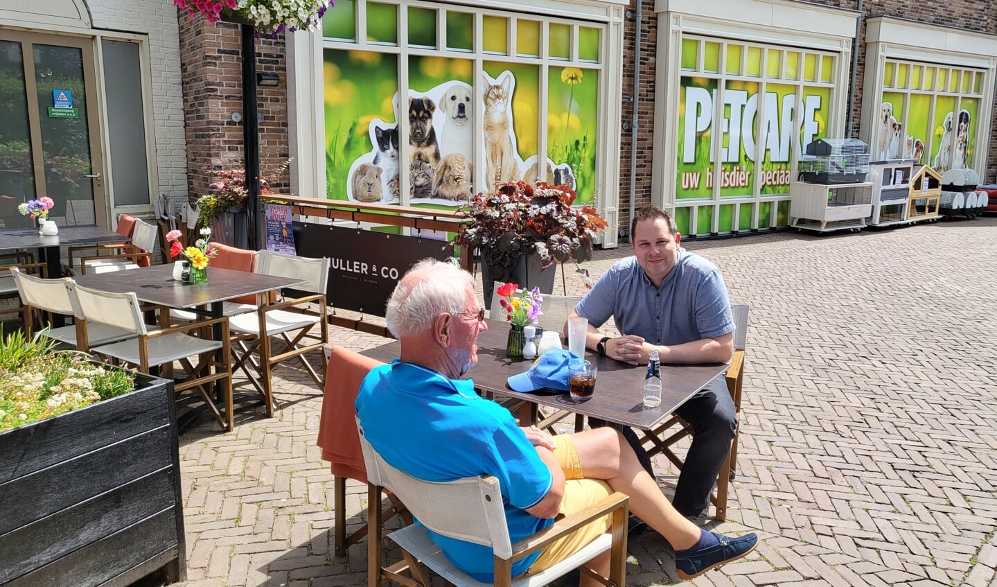 Jan Pieter Blonk (links) en Terry Duivesteijn (rechts) op het terras naast de betreffende winkel. Duivesteijn stelde vragen namens Leefbaar 3B.