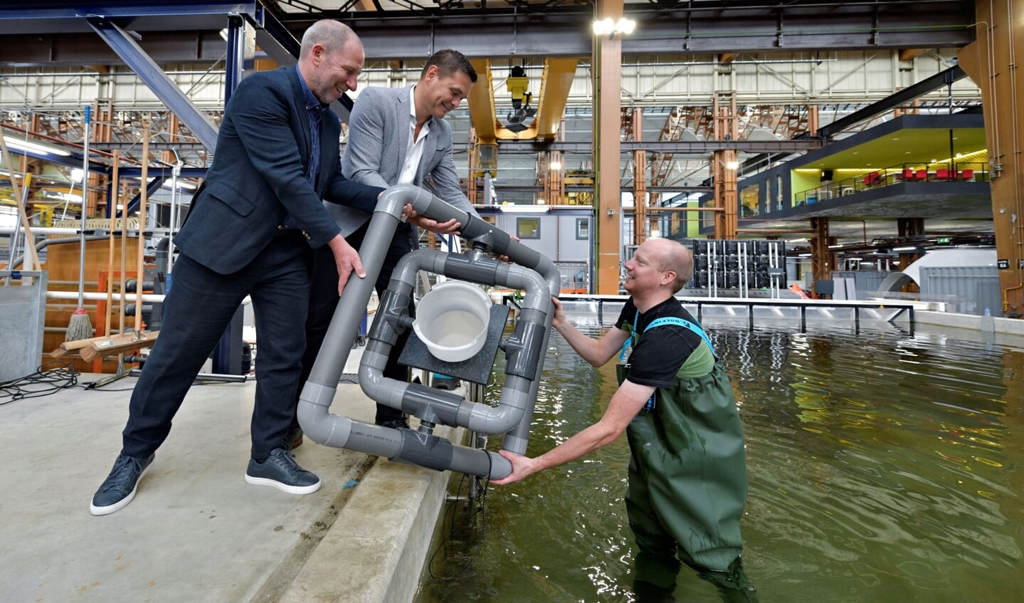 Onderzoeker en aquarist Sander van Lopik toont het drijvende kweeksysteem aan zijn directeur Erik Zevenbergen (links) en Richard van der Eijk (Havenbedrijf).
