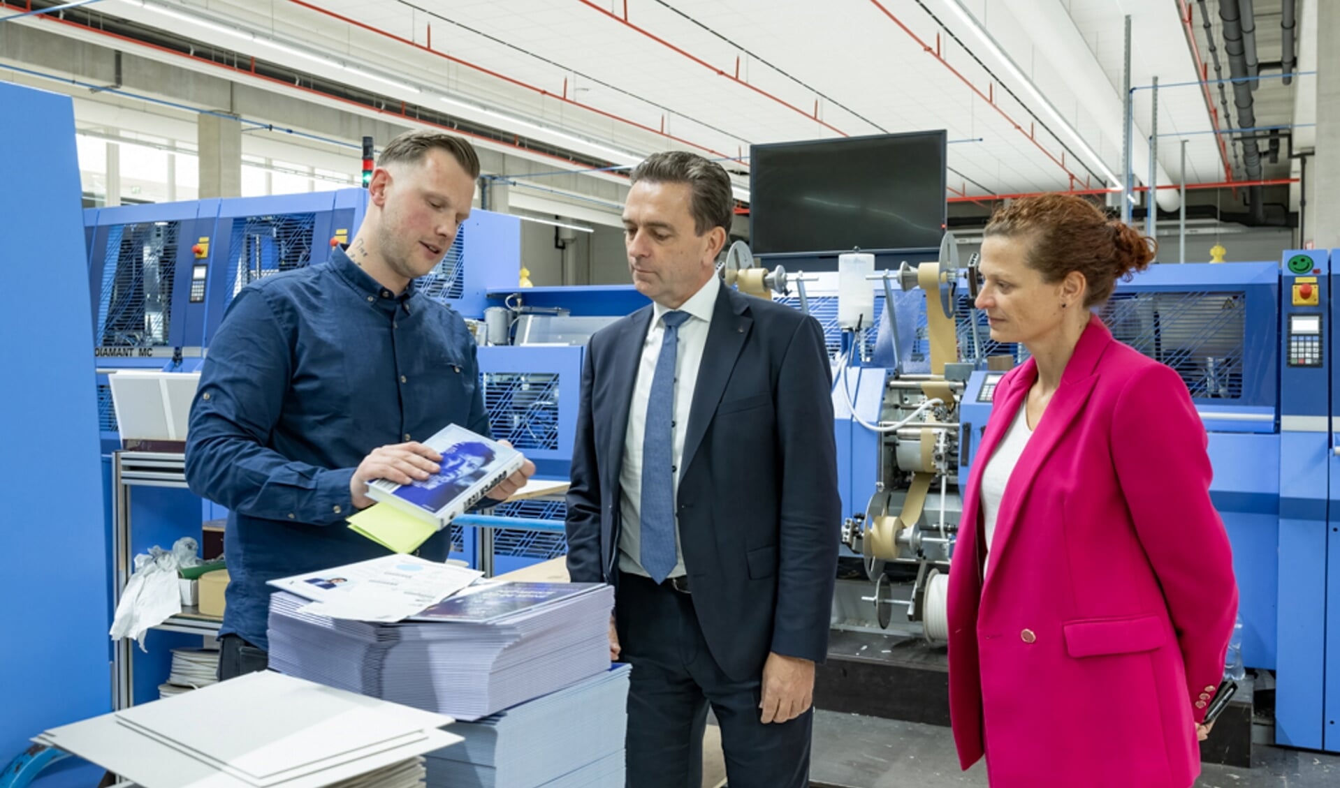 Burgemeester Bezuijen krijgt rondleiding door de binderij van NBD Biblion. v.l.n.r. Lars Goorhuis, Michel Bezuijen en Nina Nannini. (Fotografie: Wilma Helder)