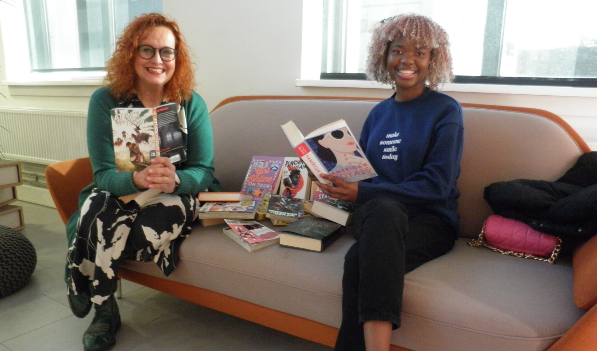 Leesconsulent Pauline Delfos (links) laat een enthousiaste jongere zien welke variatie aan boeken op de afdeling Young Adults te zien zijn, Foto Kees van Rongen