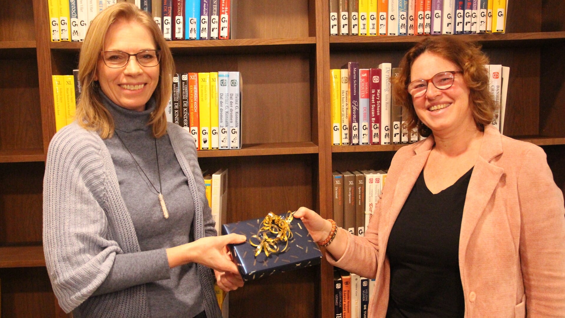 Marjolijne Braun is blij met de e-reader die ze ontving uit handen van Jacqueline van Veen van de Bibliotheek Oostland.