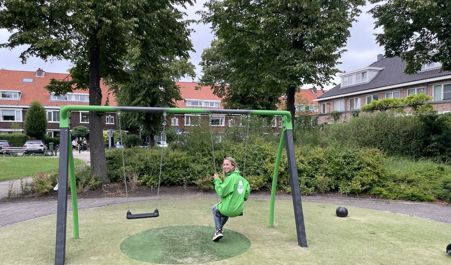 Liesbeth van der Heide in CDA jas op een groene schommel in een speeltuin te Voorburg (foto: pr).