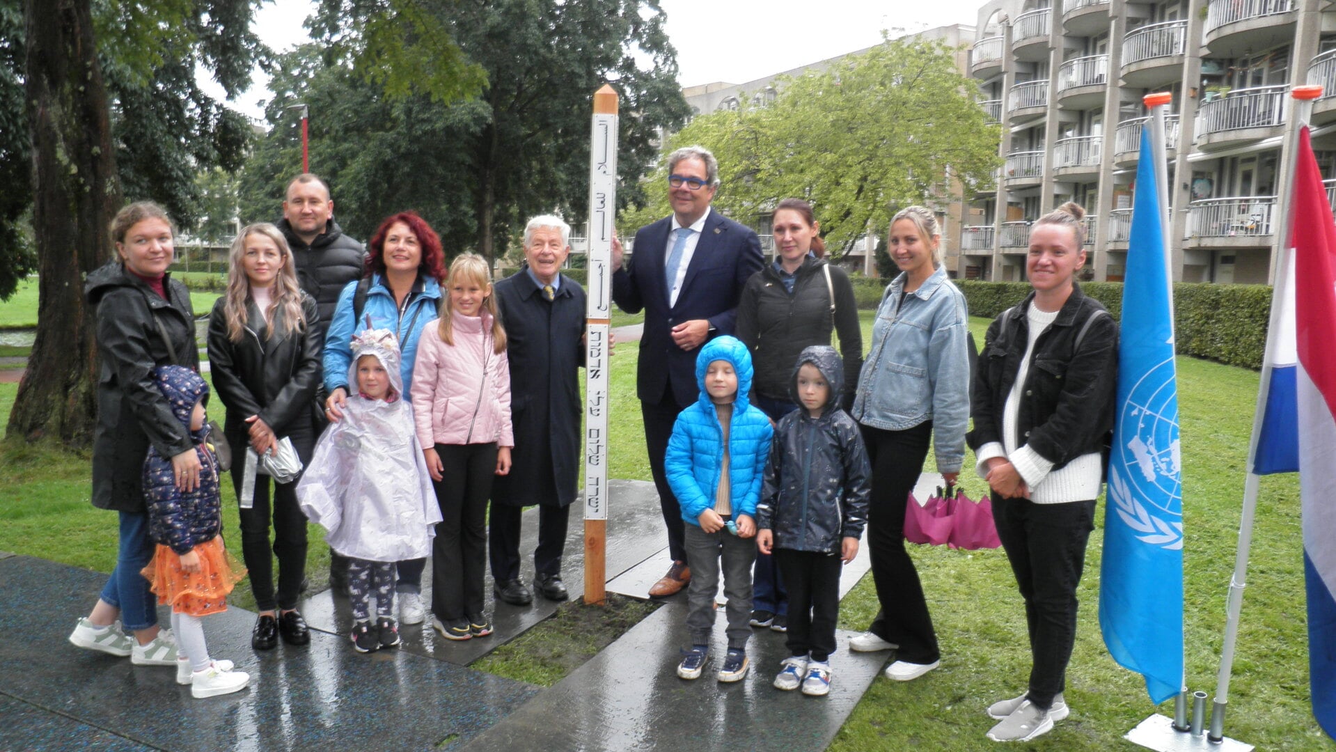 Oud-burgemeester Luigi van Leeuwen en wethouder Jan Iedema samen met Oekraïense gezinnen bij de nieuwe Vredespaal in het Dobbepark. Foto Kees van Rongen