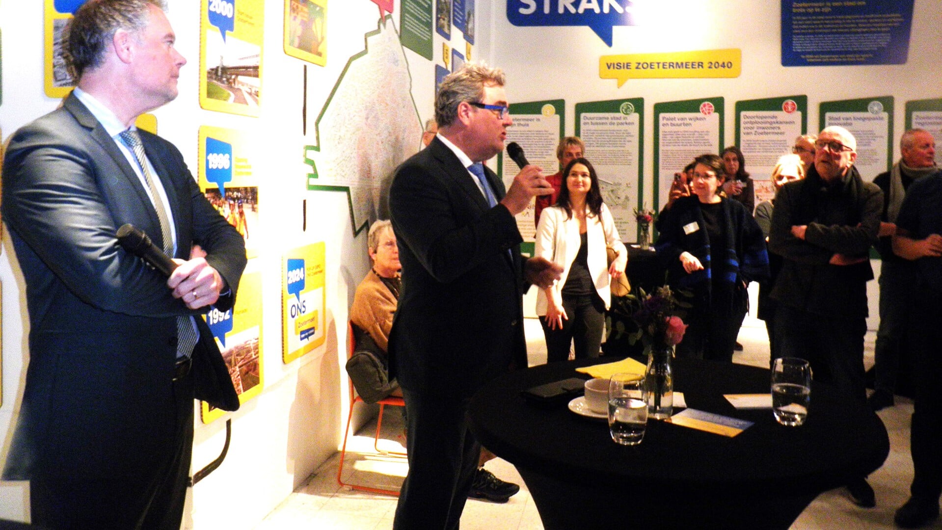 Wethouder Jan Iedema en wethouder Ronald Weerwag (links) bij de opening van pop-up expo ONS Zoetermeer-Toen, nu en straks. Foto Kees van Rongen