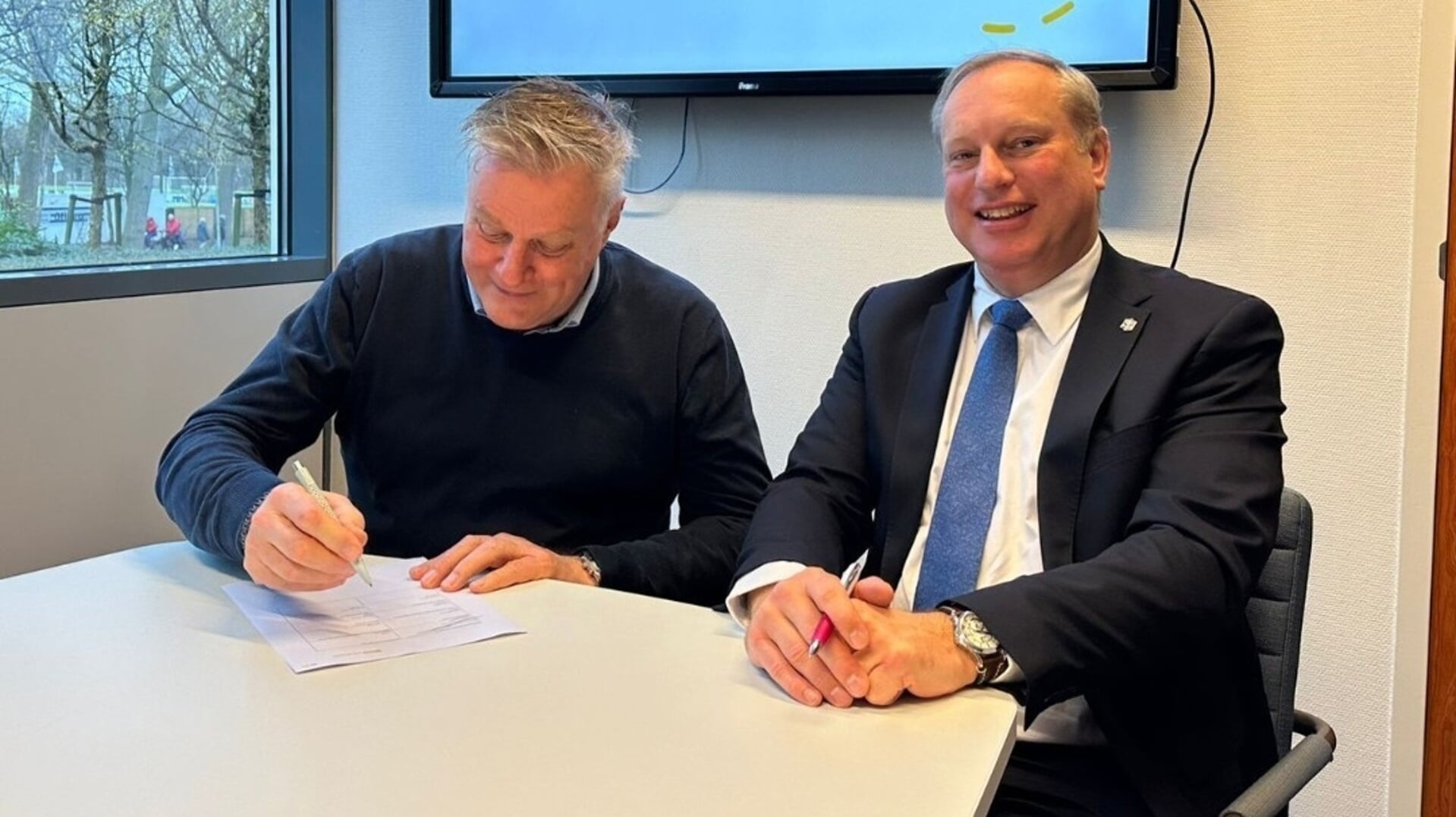 Wethouder Leon Hoek van Lansingerland (links) en wethouder Peter Hennevanger ondertekenen de overeenkomst.