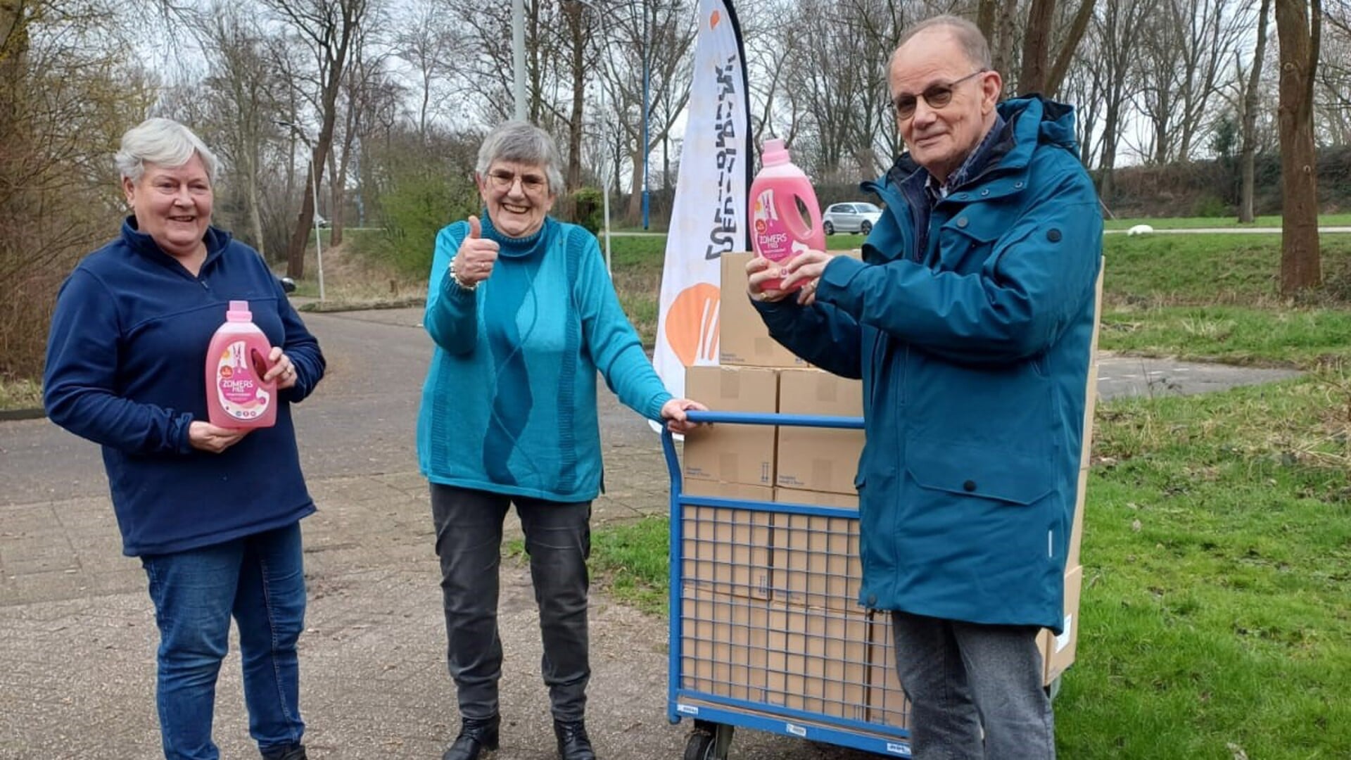Vrijwilliger van Vincentiusvereniging Jacob Ingenhoes levert de 200 flessen wasmiddel af bij de loods van de Voedselbank aan Marja Spaan (links) en Helma Santbergen. Foto: pr