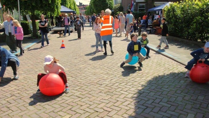 Kinderen strijden in de Oranjelust om wie er het eerst met de skippybal over de finish komt (foto: Ap de Heus).