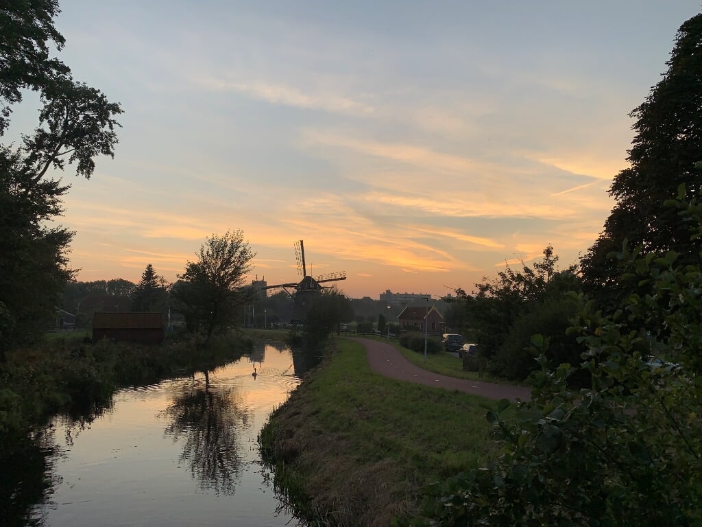 De zon gaat onder achter molen De Vlieger aan het Essepad in Voorburg (foto: Marjon de Groot-Kortekaas).