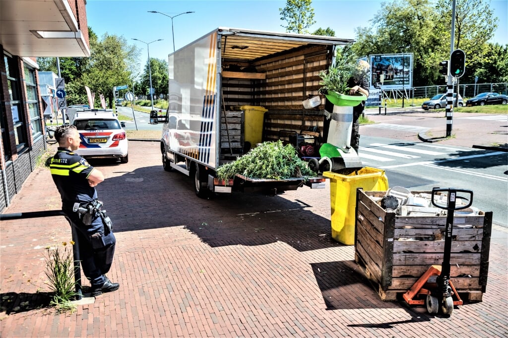 De restanten van de wietkwekerij worden onder toezicht van de politie afgevoerd op de Oude Trambaan in Leidschendam (foto; Sebastiaan Barel).