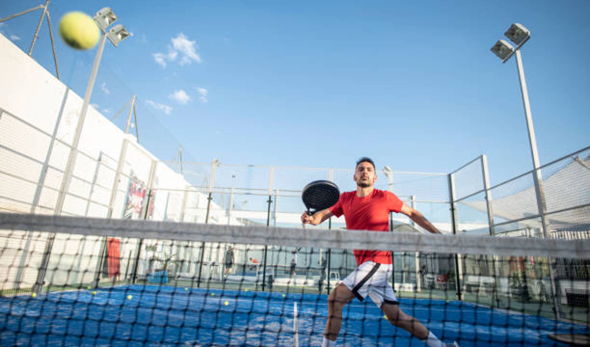 Man playing paddle tennis in court