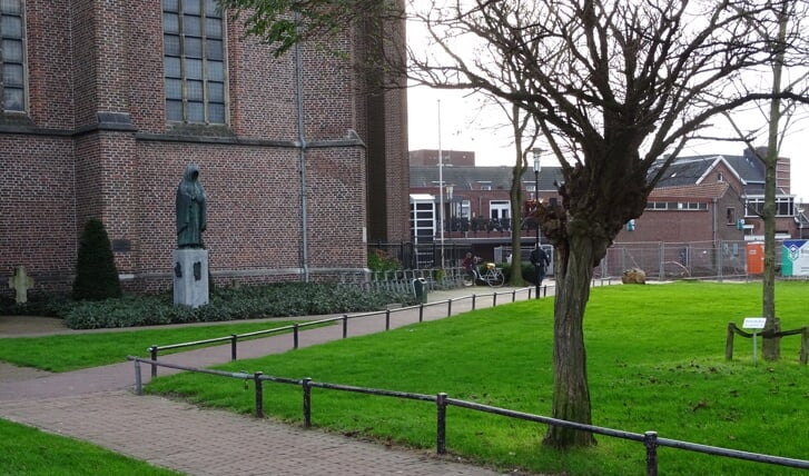 Op het voetpad langs de kerk 'waait het altijd' en het beeld van de monnik geeft geen 'warm welkomstgevoel'.