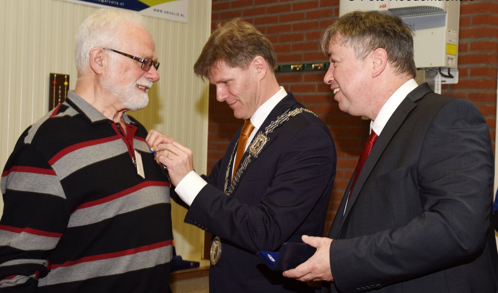 Locoburgemeester Jan Loonen speldt de onderscheiding op. Rechts gedeputeerde Patrick van der Broeck.  Foto: Hoedemaekers Venray.