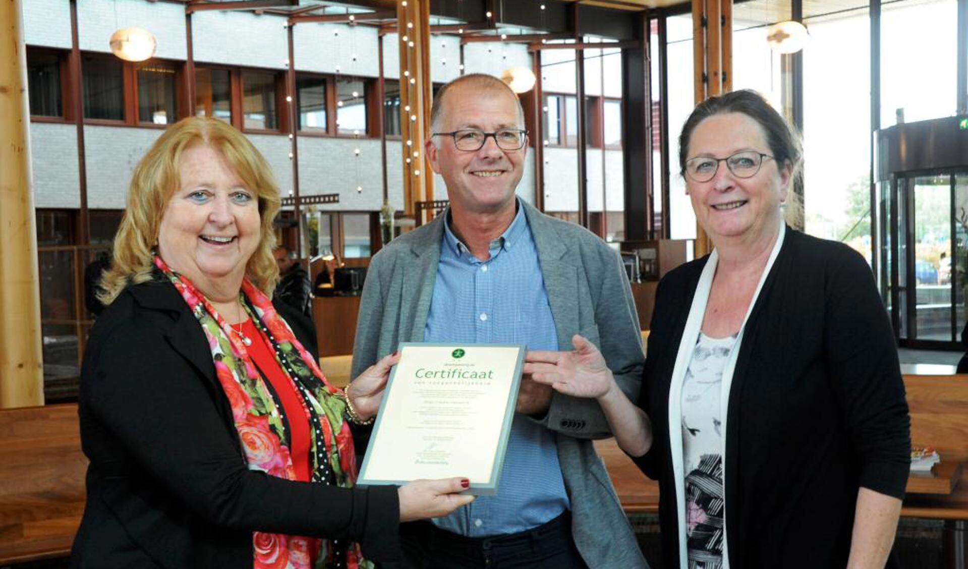 Directeur Stichting Accessibility, Yolande Mansveld, overhandigt het certificaat aan de voorzitter van de Cliëntenraad van VieCuri, Jack Arts, en lid van de Cliëntenraad Marie-Christine Hulsbeck.

