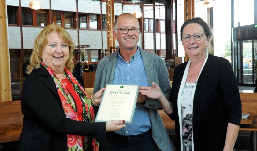 Directeur Stichting Accessibility, Yolande Mansveld, overhandigt het certificaat aan de voorzitter van de Cliëntenraad van VieCuri, Jack Arts, en lid van de Cliëntenraad Marie-Christine Hulsbeck.